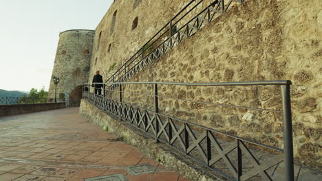 tourist man explores an ancient rural defensive castle