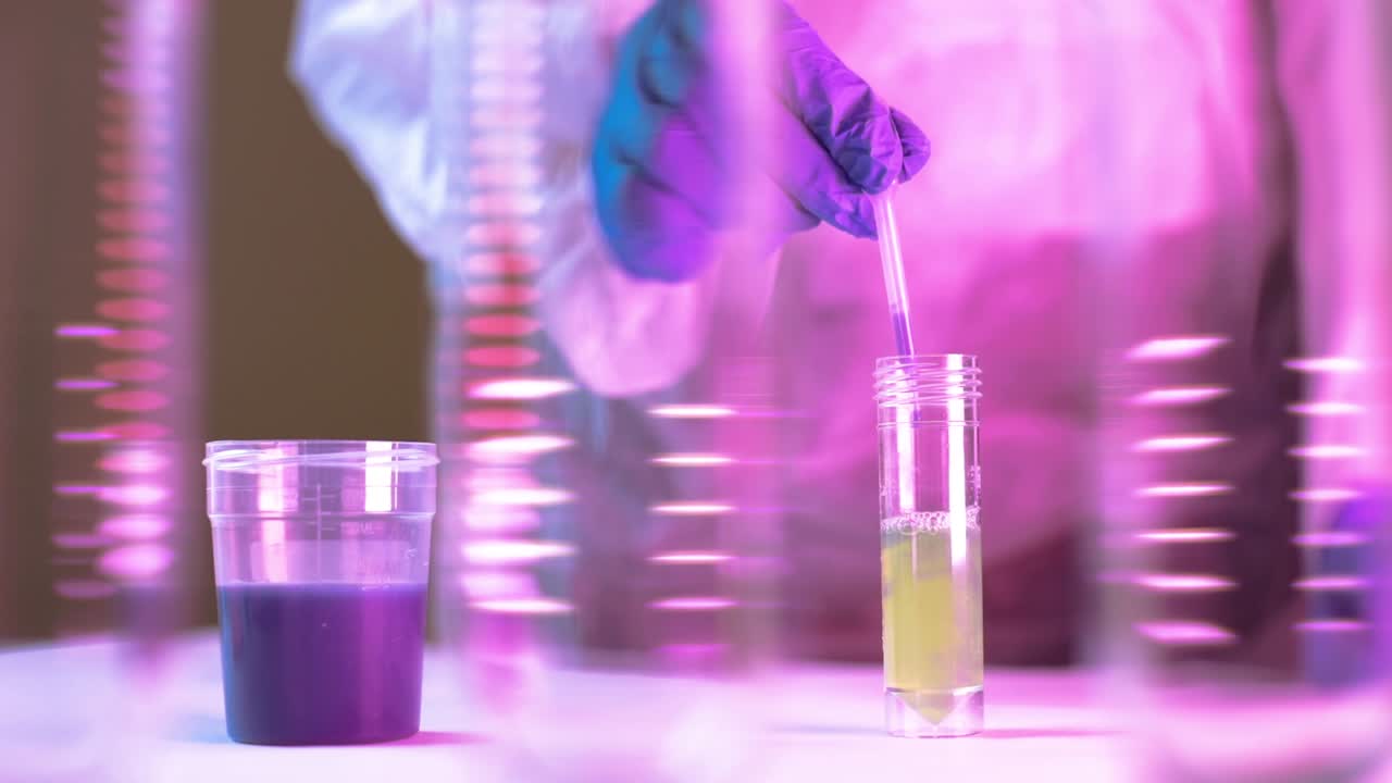 Hands wearing protecting gloves carefully drips the solution from the pipette into glass tubes for Coronavirus analysis