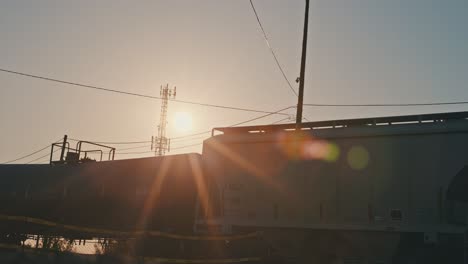 freight train cargo coming to a stop in slow motion during golden hour with sun flares cinematic