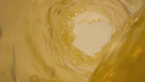 Close-up-shot-inside-of-a-glass-bottle-pouring-a-apple-juice