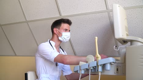 breast cancer diagnosis. young doctor in protective mask examines patient. ultrasound devices monitor close-up. possession of medical equipment