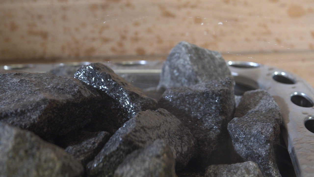 뜨거운 사우나 바위에 물을 뿌림