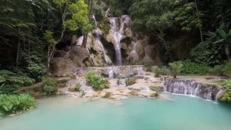 beautiful blue waterfall flowing, surrounded by trees.