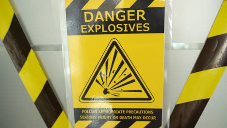 danger hazard explosion warning safety sign with yellow precaution ribbon hanging on door