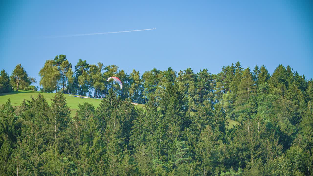 Paraglider launches from slope in Slovenj Gradec. Slow motion