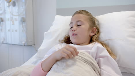 tired caucasian girl patient lying in hospital bed yawning, slow motion