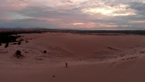 cinematic aerial drone shot of golden sunrise over the remote sand dunes of vietnam with untouched sand and cloudy sky-4