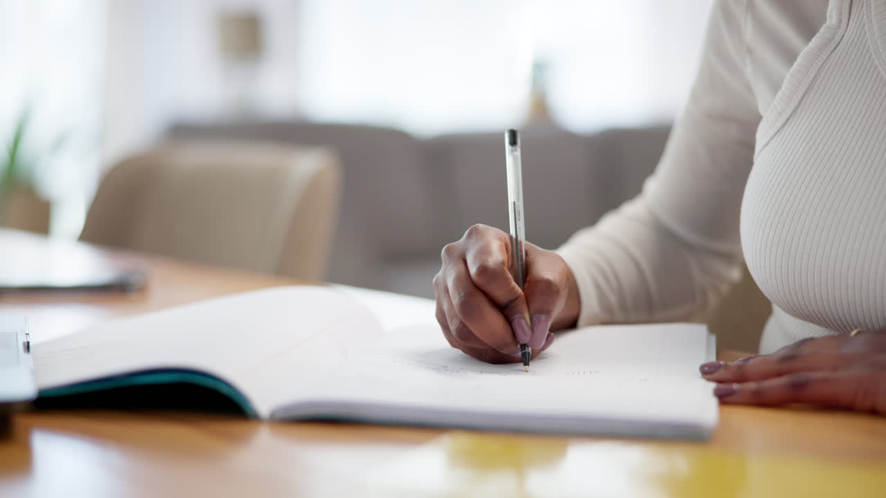 Woman Writing in a Notebook at a Desk