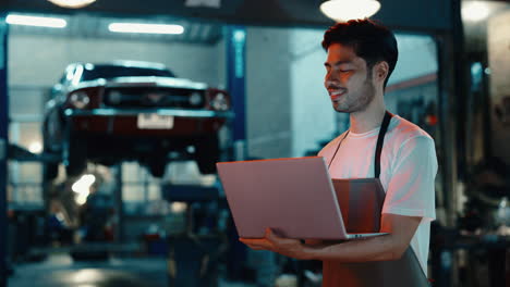 mechanic using laptop in a garage
