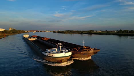 two empty container ships drive along river through zjindrecht