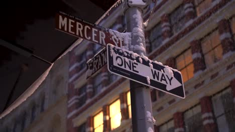 street signs at the intersection of mercer and grand streets during snowy morning before sunrise