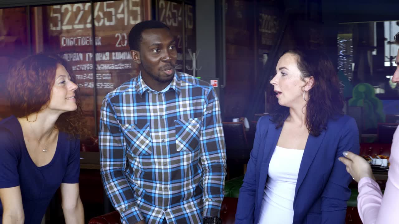 concepto de negocios, startups y personas - equipo creativo feliz con computadoras y carpetas discutiendo proyectos en un espacio compartido en el loft.