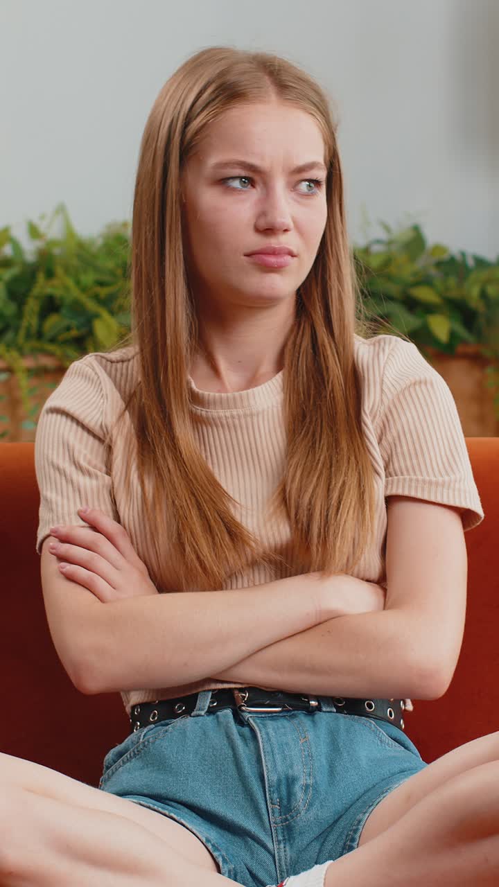 Upset young woman showing thumbs down dislike bad work disapproval dissatisfied feedback at home
