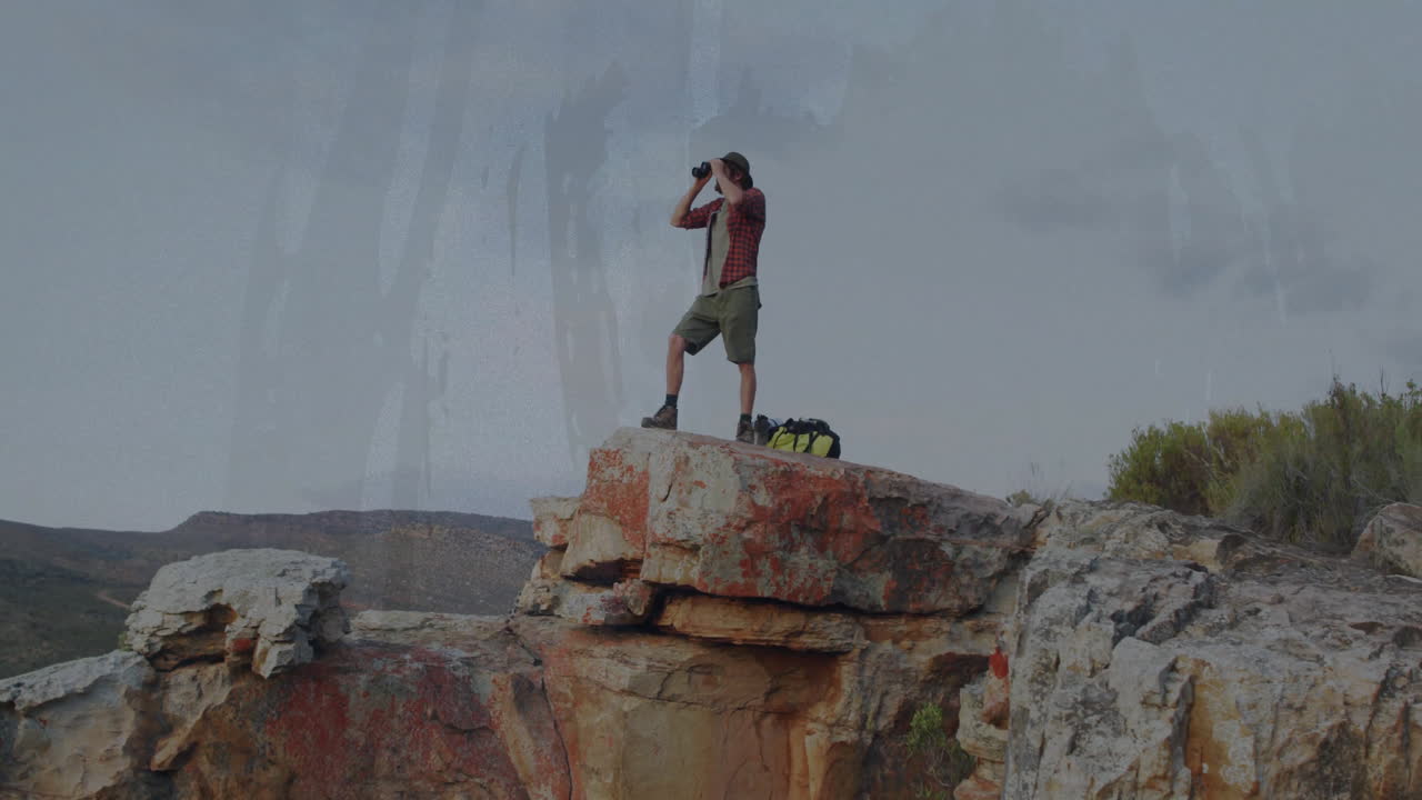 male hiker using binoculars scanning horizon on cliff, with animated tech charts and data overlays