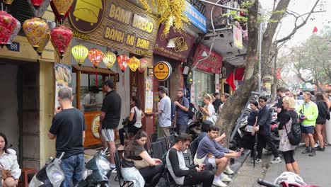 tourists queue for banh mi at street vendor