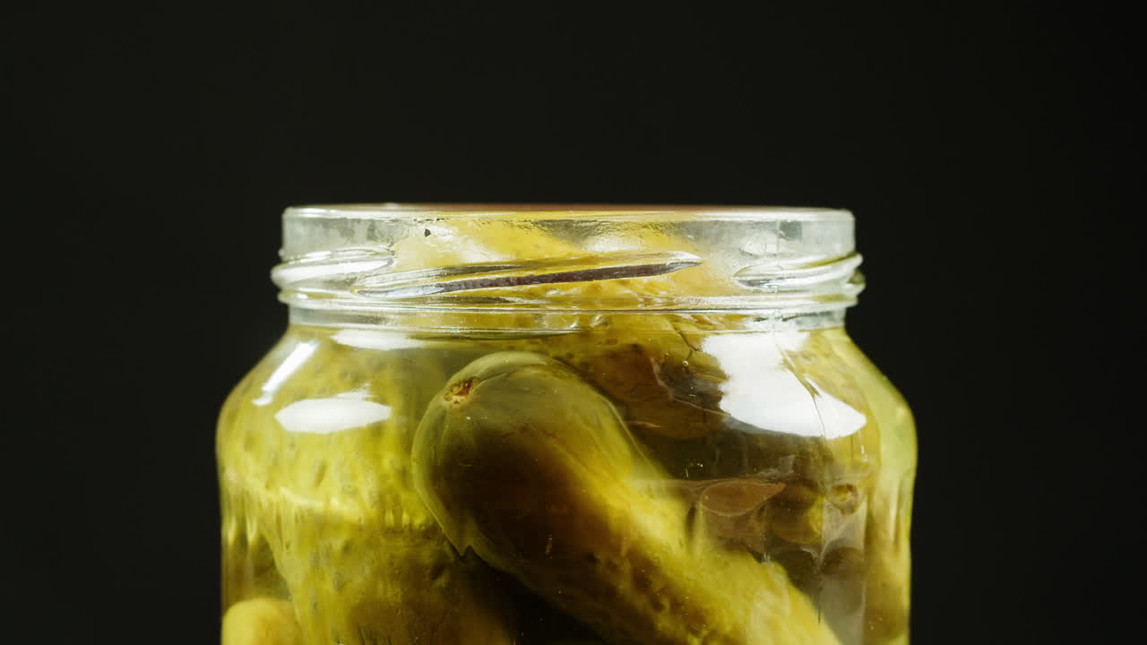 Hand placing lid on a jar of pickles