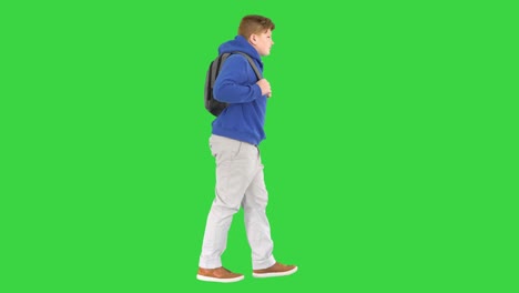 male student with a backpack walking on a green screen, chroma key