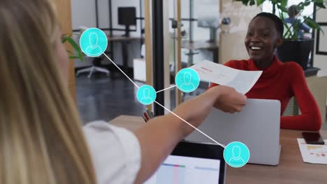 Animation of network of profile icons over diverse woman giving a document to a woman at office