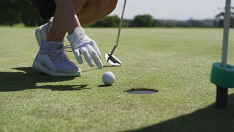 Caucasian-woman-playing-golf-reaching-for-a-ball