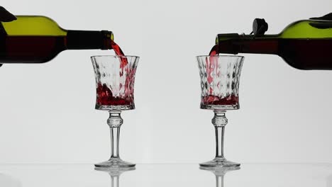 pouring red wine into two glasses