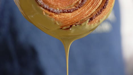 pistachio croissant donut being decorated cream dripping