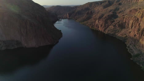 aerial - drone tilt up to reveal small dam