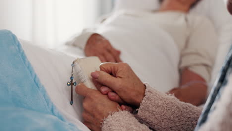 Holding-hands,-bible-and-elderly-women-in-hospital