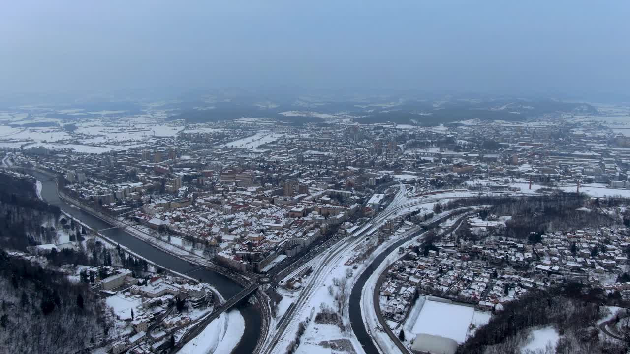 Long panning aerial clip of the snowy town of Celje in Slovenia during winter time