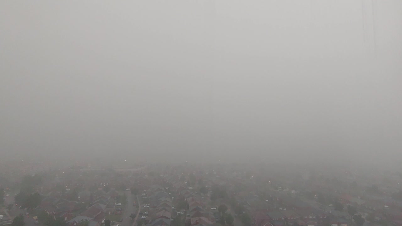 lapso de tiempo de alto ángulo de fuertes lluvias torrenciales sobre la ciudad suburbana con nubes malhumoradas que pasan