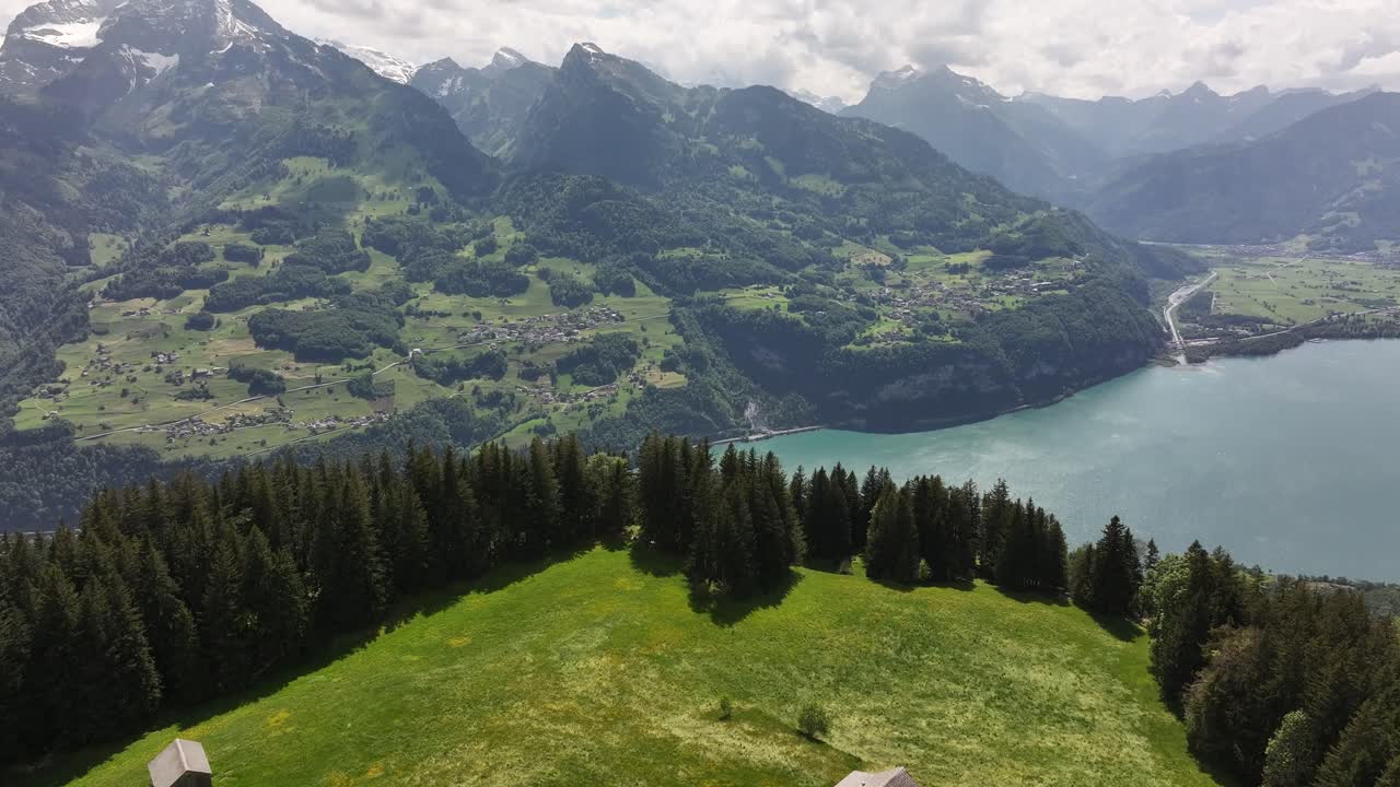 Walensee lake and Swiss Alps from Amden and Arvenbüel in Switzerland beautiful aerial drone view, green hills, snow peaks and clear water