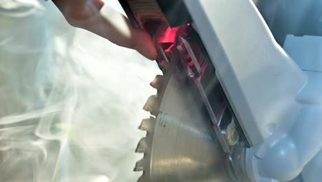 close-up machine circular saw in wood in smoke.