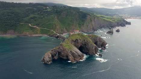 Océano-Ondulado-Cerca-De-La-Montaña-Verde-Con-Pasarela-Bajo-El-Cielo