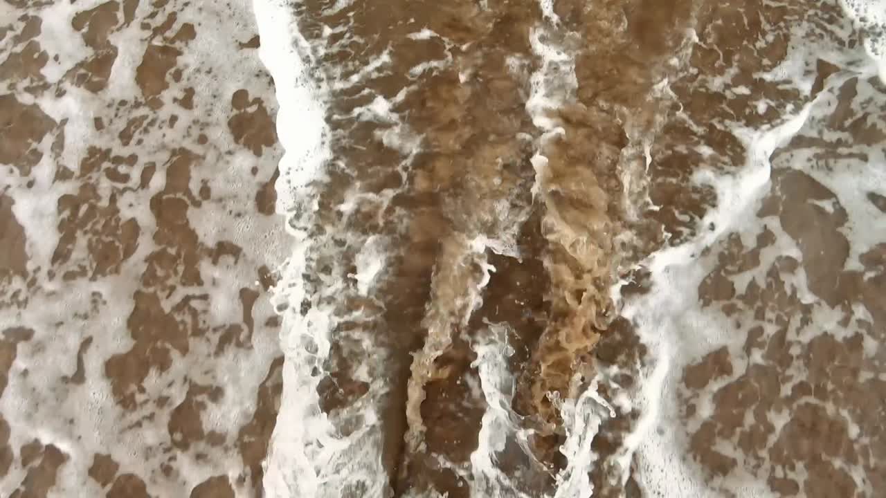 Close up top view shot of beach waves. Static