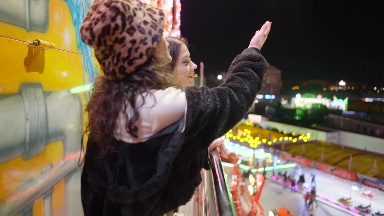 Teenage girls at a funfair at night