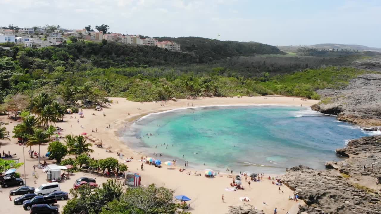 drone volando hacia atrás en una pequeña playa
