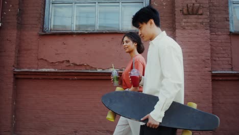 young couple skateboarding and enjoying drinks