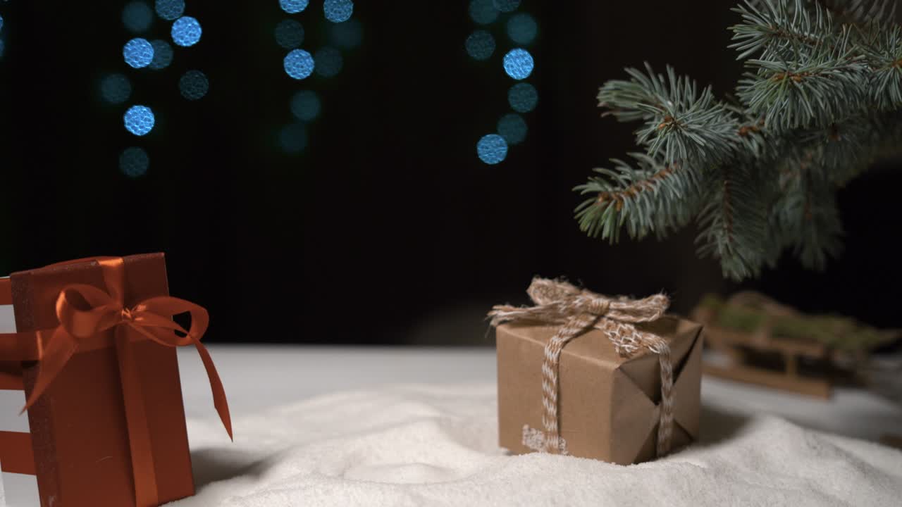 en el fondo de navidad una mano femenina colocó una caja empaquetada en papel de artesanía.