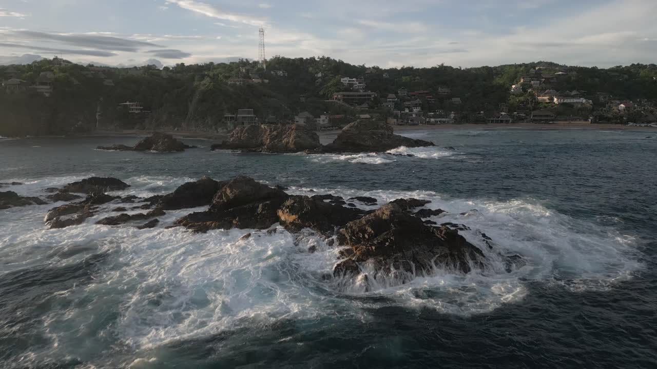 salpicaduras de espuma de agua blanca en rocas escarpadas de la costa en mazunte, méxico
