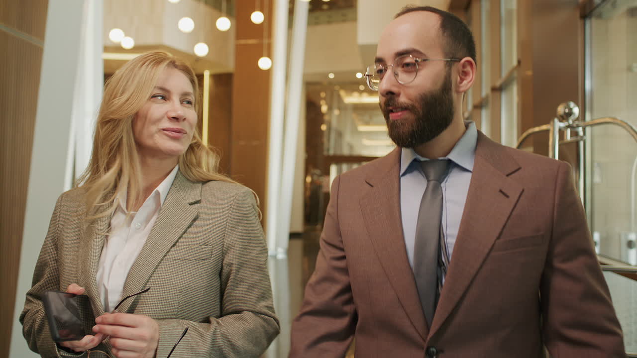 Colleghi d'affari che conversano camminando nella hall di un hotel moderno