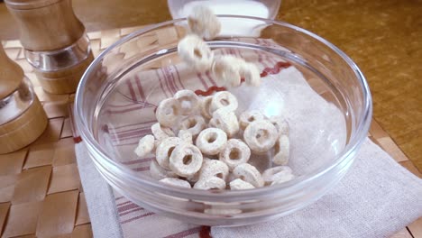 copos de avena crujientes en un tazón para un delicioso desayuno matutino con leche. cámara lenta con toma de seguimiento de rotación.