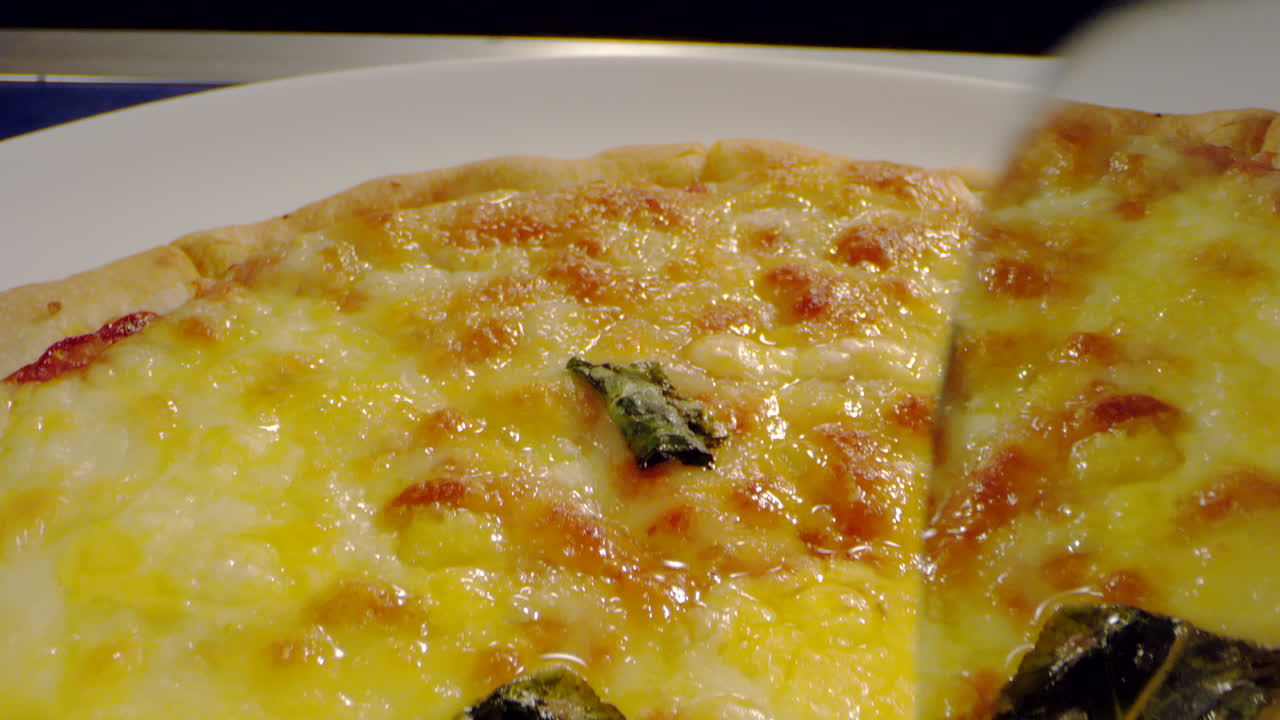 toma macro cortando pizza con queso y salsa de tomate