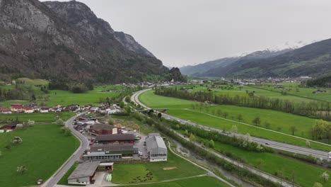 Carretera-Con-Coches-Que-Pasan-A-Través-De-Un-Valle-Entre-Las-Montañas-Cerca-De-La-Ciudad-De-Walenstadt.