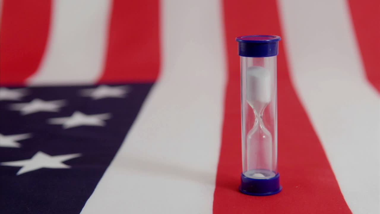 An American flag lies beneath a run hourglass