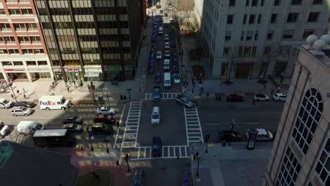 Tilt-down-shot-of-traffic-on-road-intersection-in-city.-Busy-streets-surrounded-by-tall-buildings.-Boston,-USA