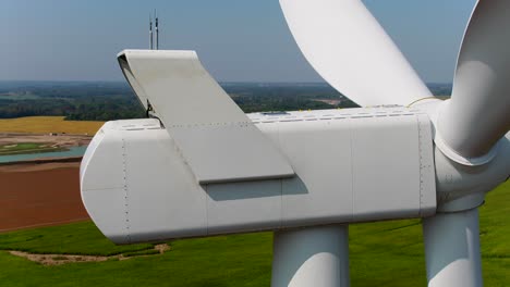 wind turbine's nacelle exterior box with generator and gears, close up aerial shot panning