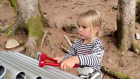 cute young girl having a good time playing huge xylophone outdoors in theeme park - handheld static - mikkelparken norway