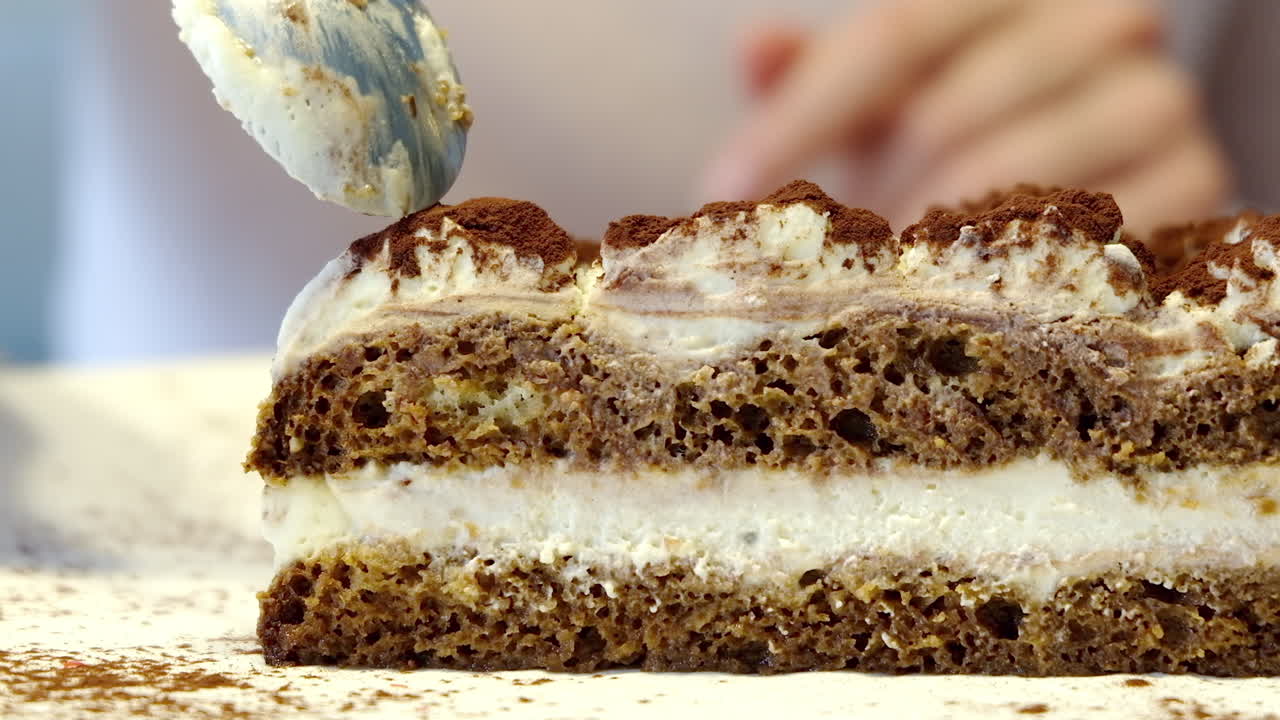 Close up of a woman eating tiramisu at a cafe