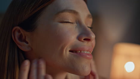 woman massaging face at evening in home closeup. girl touching skin