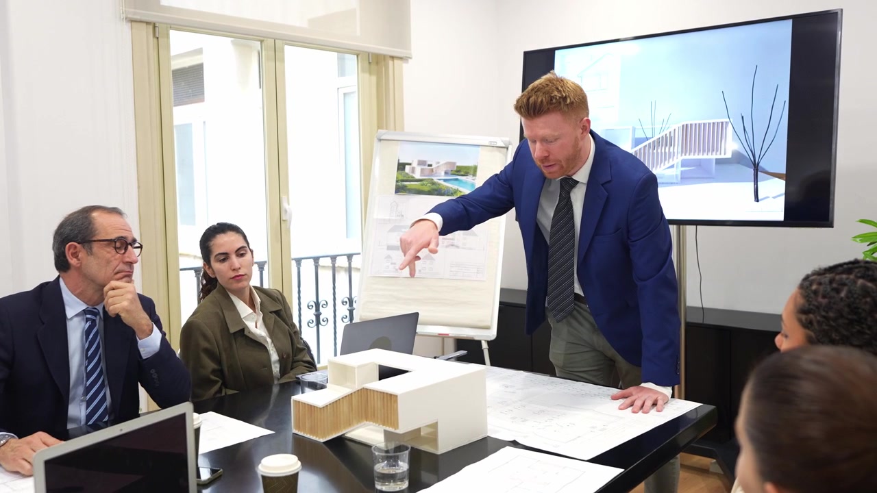 Architetto presenta plastico e planimetrie al team aziendale