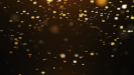 oro, partículas brillantes se desvanecen dentro y fuera, flotando hacia abajo en un fondo oscuro en cámara lenta